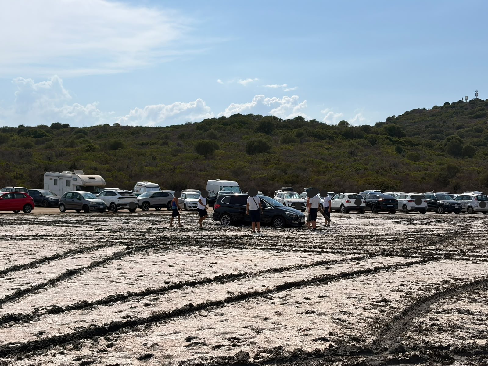 Cala Banana, sole a picco e ruote nel fango: amara sorpresa nel parcheggio